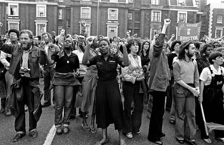 Crowds of people raising their arms up in protest at The Battle of Lewisham 1977