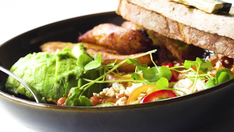 Plate of breakfast, includes avocado, toast, tomatoes and plantain.