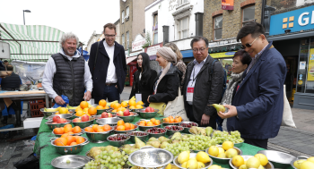 Delegates from the International Markets Conference meet with market stallholder