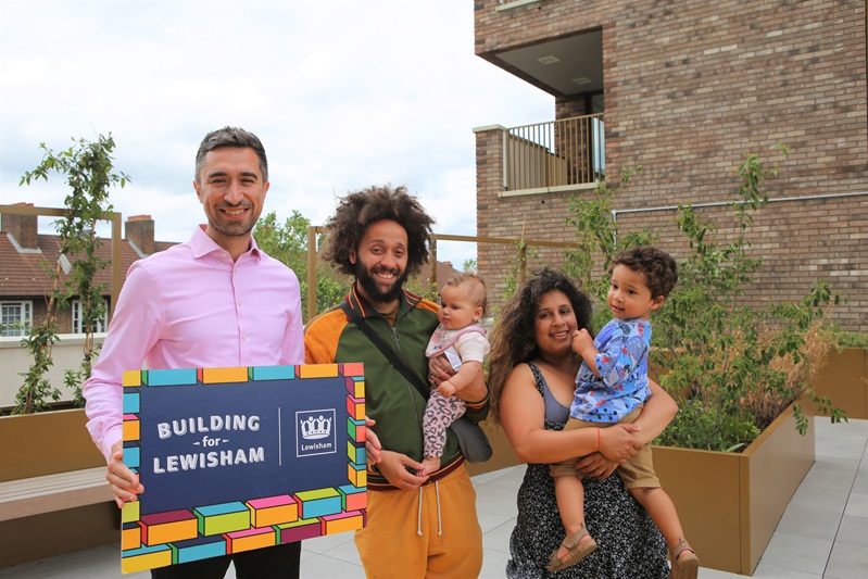 The Mayor of Lewisham, Damien Egan, with two adults and two small children. Damien Egan is holding a sign reading 'Building for Lewisham'.