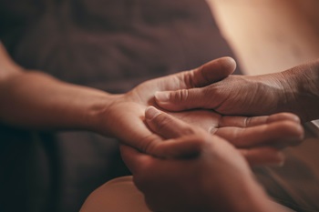 Hands massaging another person's hand