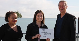 Female student holds up a sign reading 'Abby Cambridge University HSPS'. Councillors are stood either side of her smiling.