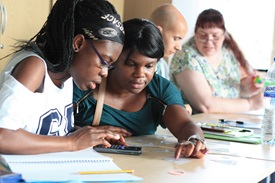 Two women working together on a maths problem.