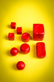 Red clay shapes on yellow background.