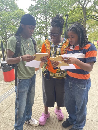 Rosamund Adoo-Kissi-Debrah and two A level students reading their results