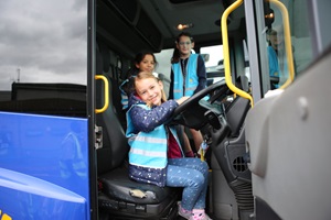 A child smiles at the camera sitting in a lewisham council bin truck