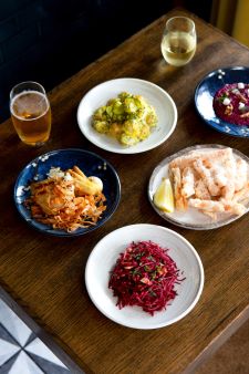Five tapas style dishes arranged on a wooden table