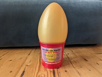 Golden egg in red pot with competition label on pot