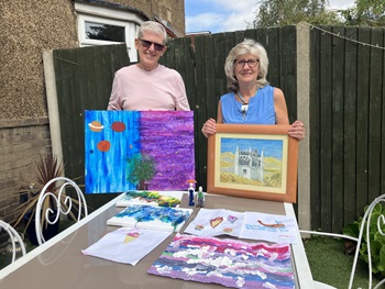 Foster carers Eva and Francis holding pieces of art