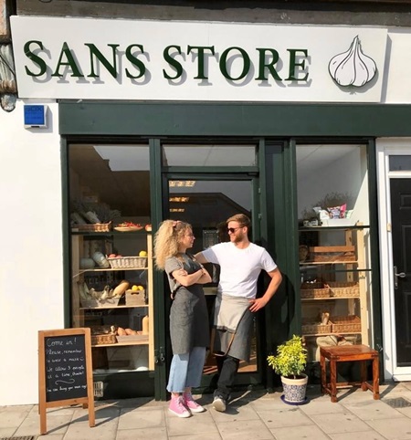 Outside the shopfront of Sans Store in Forest Hill, shop owners Max and Cloé stand outside laughing