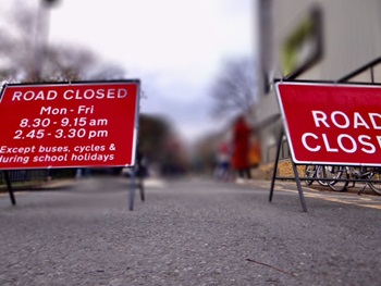 A photo of two road closure signs on a road